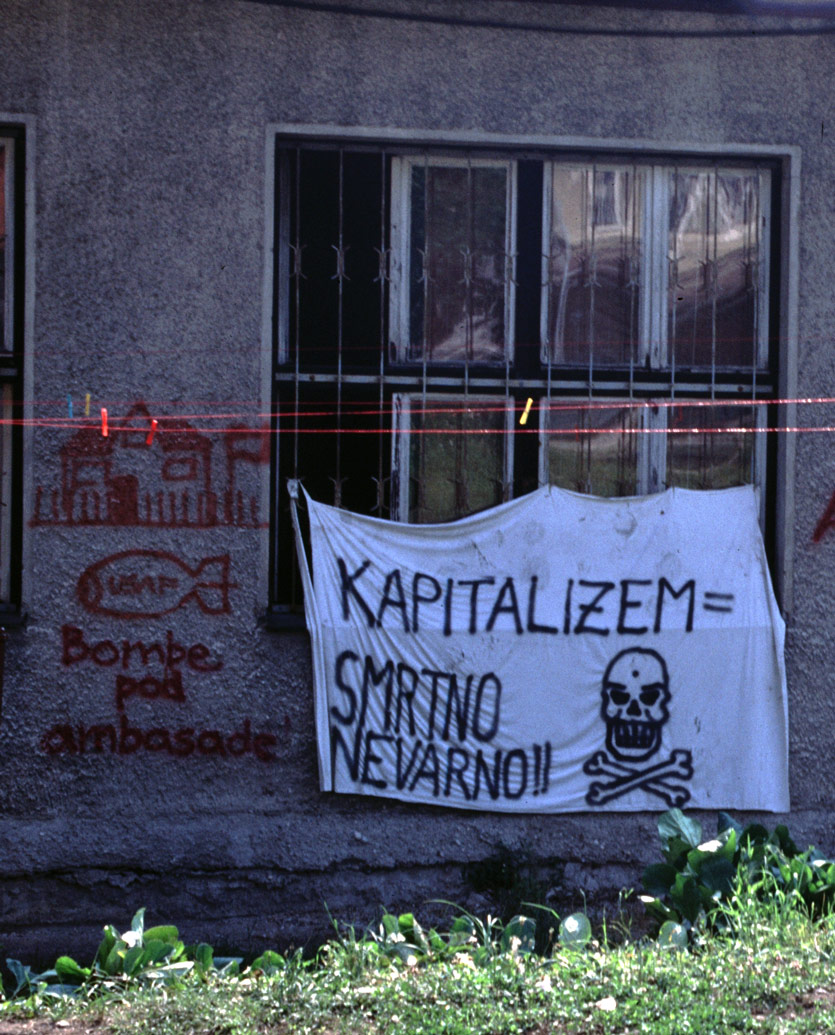 an abandoned building, now occupied, with protest banners in the window, being used as community organizing location